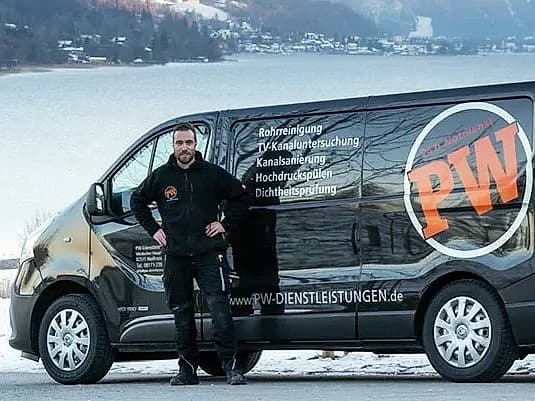 Techniker der PW Rohrreinigungs GmbH vor dem Einsatzfahrzeug mit Kanalreinigungsmaschine
